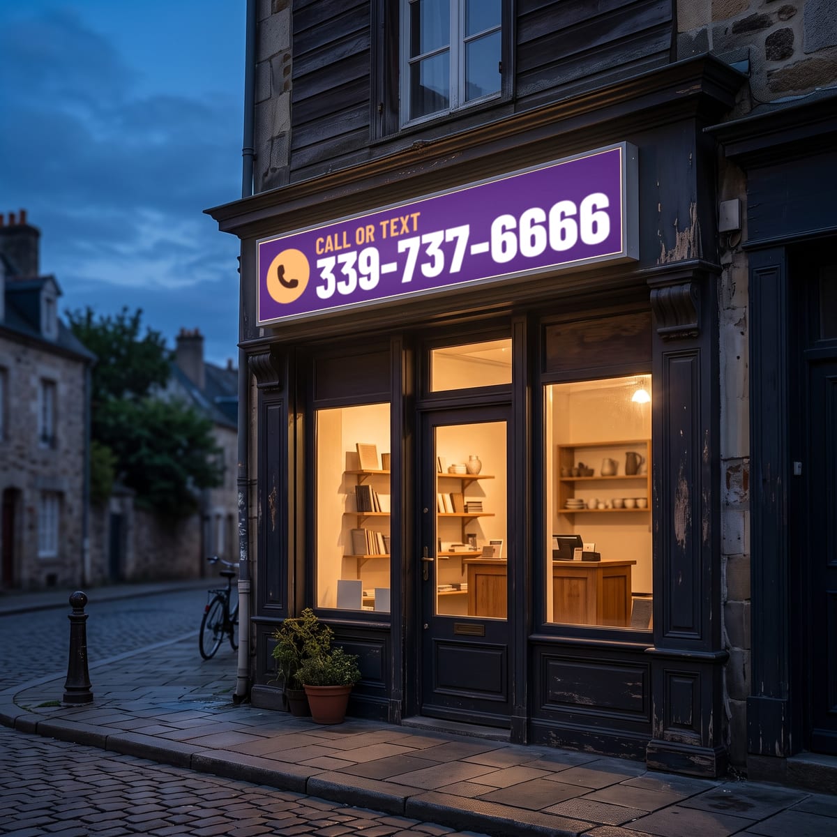 (339) 737-6666 on a lit shop sign