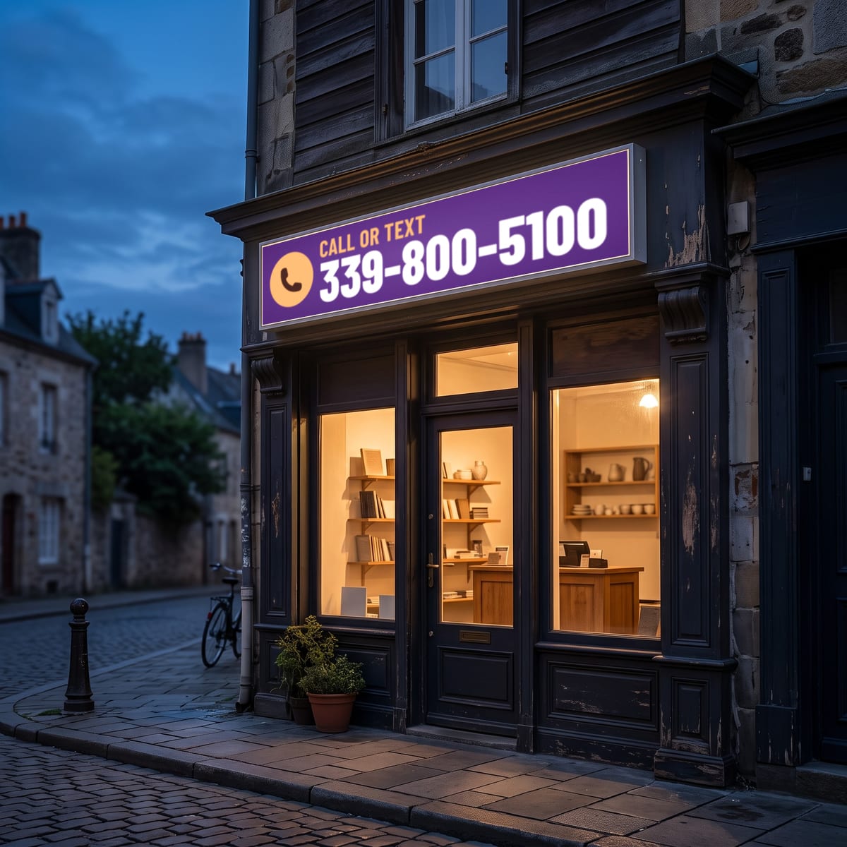 (339) 800-5100 on a lit shop sign